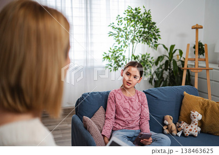 Child talking to adult during mental health therapy session Child talking to adult during mental health therapy session 138463625