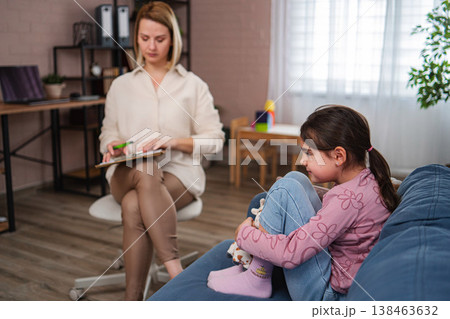 Child receiving counseling from psychologist during therapy session Child receiving counseling from psychologist during therapy session 138463632