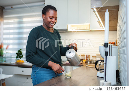 Woman pouring hot water making lemon tea in kitchen 138463685