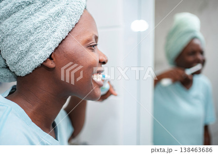 Smiling woman brushing teeth during morning hygiene routine Smiling woman brushing teeth during morning hygiene routine 138463686