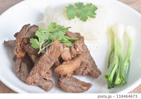 salty dry fried slice beef meat fermenting in sesame oil and pepper with sticky rice topping parsley on plate salty dry fried slice beef meat fermenting in sesame oil and pepper with sticky rice topping parsley on plate 138464673