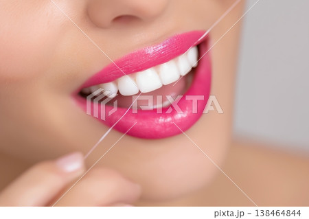 Radiant smile perfection with bright white teeth and flawless pink lips while flossing Radiant smile perfection with bright white teeth and flawless pink lips while flossing 138464844