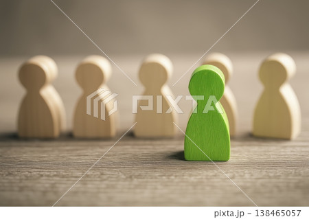 Green figure stands out among wooden figures, a concept for individuality and leadership Green figure stands out among wooden figures, a concept for individuality and leadership 138465057