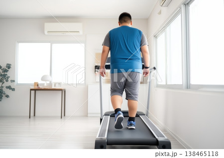 Overweight Man Walking on Treadmill at Home Overweight Man Walking on Treadmill at Home 138465118
