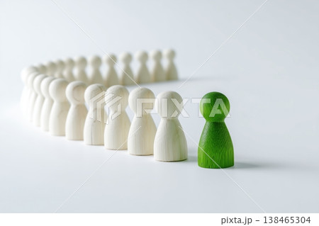 Stand out from the crowd with green wooden figure in front of a row of white figures indicating uniqueness, leadership, or individuality. 138465304