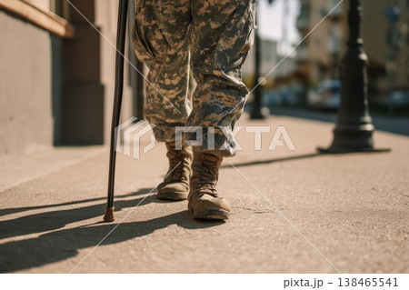 Camouflage uniform shows a veteran walking with a cane on the sidewalk, capturing resilience and service Camouflage uniform shows a veteran walking with a cane on the sidewalk, capturing resilience and service 138465541