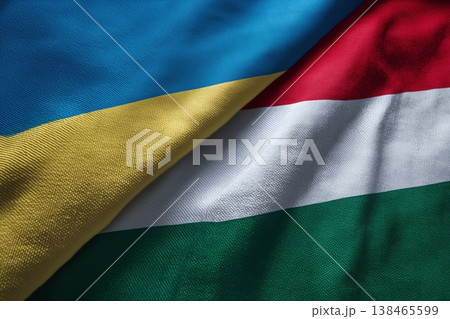 Ukrainian and Hungarian flags intertwine showcasing geopolitical relations and diplomatic ties between the nations Ukrainian and Hungarian flags intertwine showcasing geopolitical relations and diplomatic ties between the nations 138465599