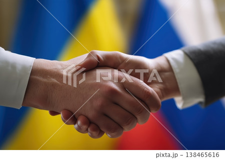 Diplomacy shown with a handshake between Russia and Ukraine set against their national flags emphasizing global politics 138465616