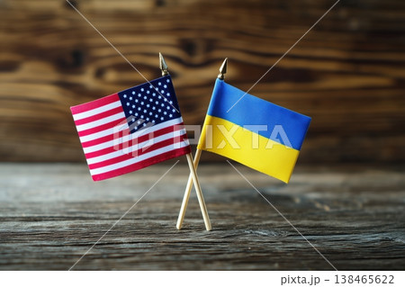 United States and Ukraine flags crossed symbolize international relations and unity on a rustic wooden background United States and Ukraine flags crossed symbolize international relations and unity on a rustic wooden background 138465622