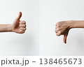 Approval and disapproval is shown with two hands, one with thumbs up, other with thumbs down on a clean white background. 138465673