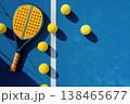 Get active with a vibrant padel tennis racket and balls on a bright blue court, ready for a dynamic game 138465677