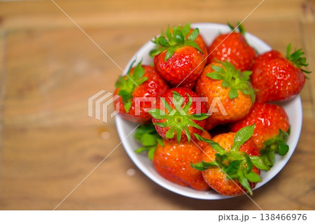 Ripe fresh strawberries in a white bowl on a wooden surface, organic food concept. 138466976