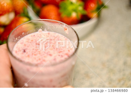 Fresh strawberry smoothie in a glass with ripe strawberries in the background, healthy breakfast concept. 138466980