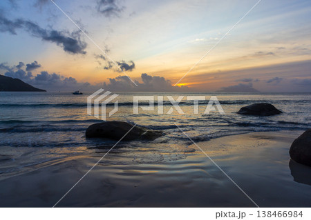 Golden sunset paints pastel skies above a rocky beach Golden sunset paints pastel skies above a rocky beach 138466984