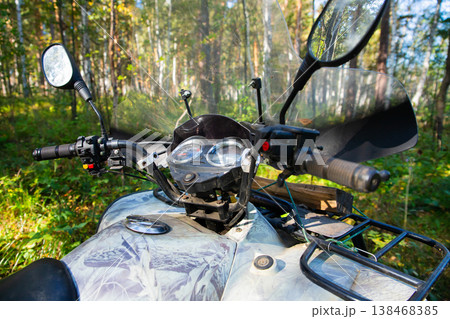 All Terrain Vehicle outside. ATV Quadbike parked in a dense forest during a clear day exploring nature's beauty and adventure All Terrain Vehicle outside. ATV Quadbike parked in a dense forest during a clear day exploring nature's beauty and adventure 138468385