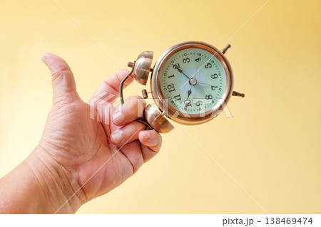 Vintage Alarm clock in hand,Time in hand concept. Vintage Alarm clock in hand,Time in hand concept. 138469474