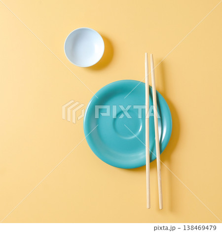 Plate and Chopsticks and small bowls on color background. Plate and Chopsticks and small bowls on color background. 138469479