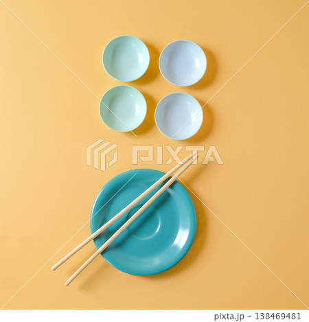 Plate and Chopsticks and small bowls on color background. Plate and Chopsticks and small bowls on color background. 138469481