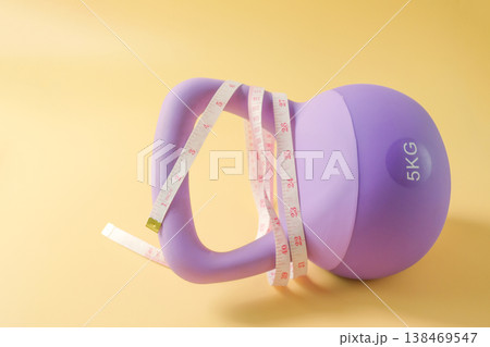 A measuring tape wrapped on kettlebell for strength training. 138469547