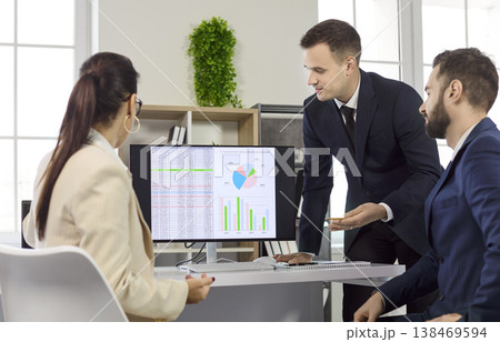 Business team meeting on strategy and data analytics, monitor with infographics Business team meeting on strategy and data analytics, monitor with infographics 138469594