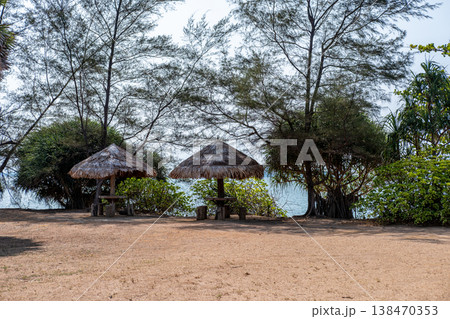 Seating under a wooden hut shelter, located by the sea. 138470353
