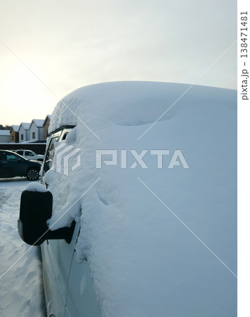 Snow covers a van in a parking lot as the sun rises on a cold winter morning Snow covers a van in a parking lot as the sun rises on a cold winter morning 138471481
