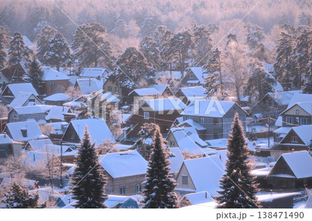 Winter view of houses covered in snow in a forested area during early morning light Winter view of houses covered in snow in a forested area during early morning light 138471490