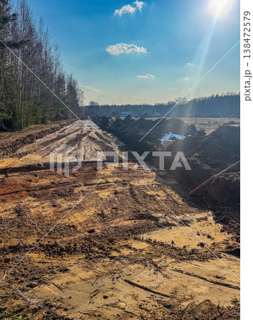 Construction of a new road or pipeline in a rural landscape on a sunny spring day. Construction of a new road or pipeline in a rural landscape on a sunny spring day. 138472579
