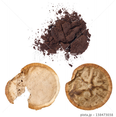 A pile of ground coffee and two used paper coffee filters with stains on an isolated background A pile of ground coffee and two used paper coffee filters with stains on an isolated background 138473038