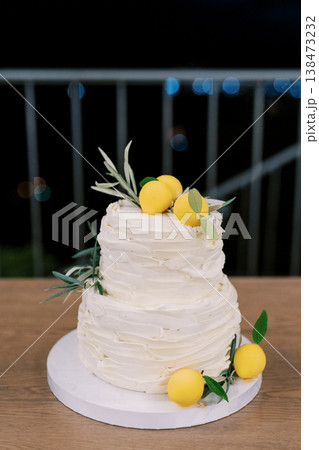 Photograph Of Detailed Icing On Tiered Cake With Herbs And Lemons Surrounding 138473232