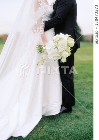 Closeup Of Newlyweds With Beautiful Floral Arrangement And Classic Attire Closeup Of Newlyweds With Beautiful Floral Arrangement And Classic Attire 138473273