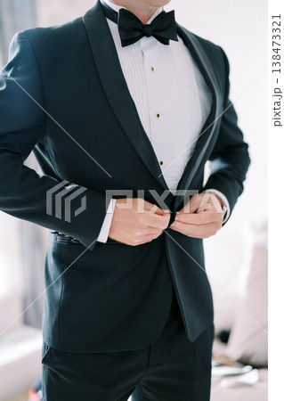Groom Meticulously Adjusts His Tuxedo For Upcoming Wedding Ceremony 138473321