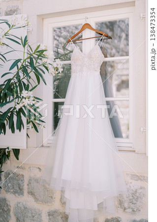 Beautiful Bridal Gown Draped Delicately With Leafy Surroundings Nearby Beautiful Bridal Gown Draped Delicately With Leafy Surroundings Nearby 138473354