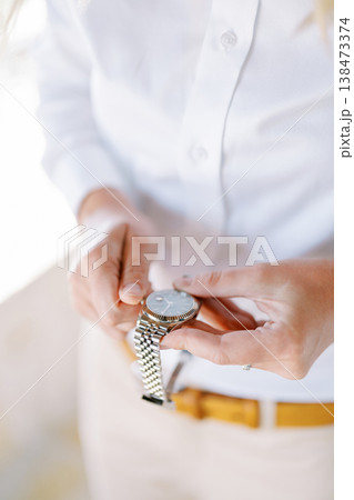 Closeup Of Person Adjusting Exquisite Silver Timepiece During Dawn Closeup Of Person Adjusting Exquisite Silver Timepiece During Dawn 138473374