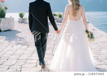 Romantic Wedding Scene With Lovers Walking Along Peaceful Seafront Promenade 138473405