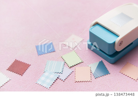 Punching decorative paper shapes for creative scrapbooking craft 138473448