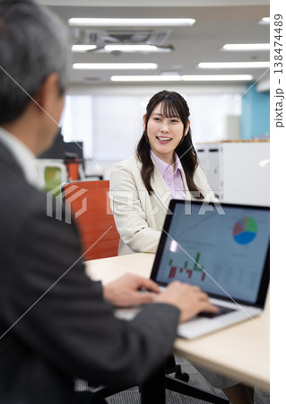 パソコン画面を見ながら打ち合わせをする男女 パソコン画面を見ながら打ち合わせをする男女 138474489