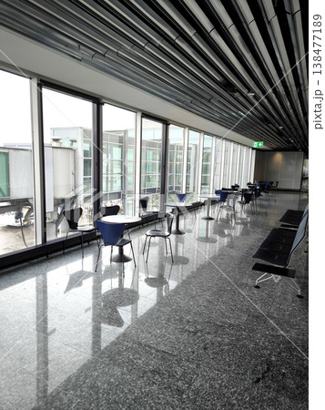 The interior of the airport terminal with panoramic windows and a passenger lounge area The interior of the airport terminal with panoramic windows and a passenger lounge area 138477189
