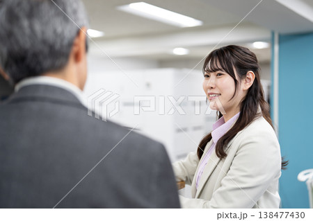 社内で打ち合わせをするビジネスパーソンの男女 社内で打ち合わせをするビジネスパーソンの男女 138477430