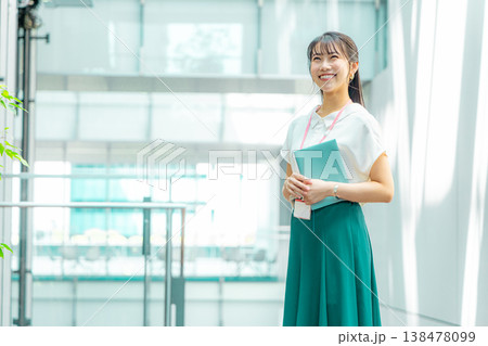 手帳を持って廊下を歩く若い女性 手帳を持って廊下を歩く若い女性 138478099