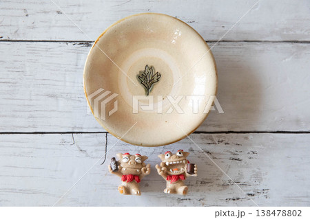 ナチュラルな白木目に置かれた沖縄の焼き物　シーサー 138478802