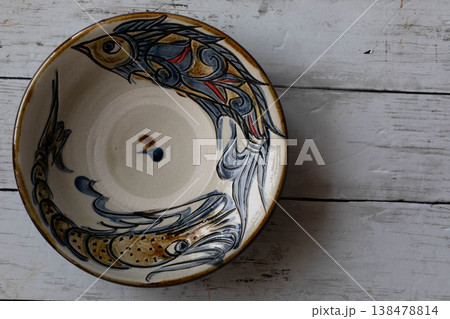 沖縄の伝統工芸 やちむんの魚紋皿と白木目のコピースペース 138478814