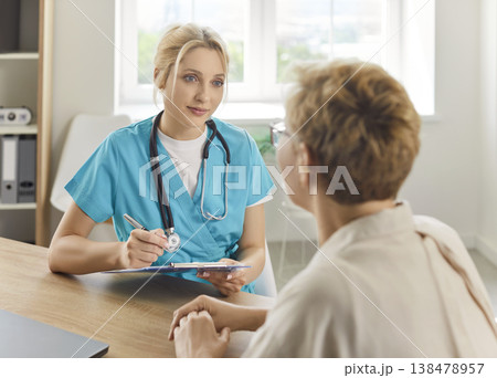 Senior patient at doctors appointment in hospital, general practitioner holding clipboard to listen 138478957