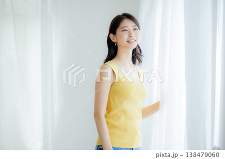 カーテンを開ける女性 138479060