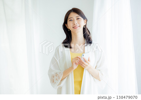 家でスマホを見る若い女性 138479070