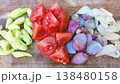 Close-up of fresh green chilies, red tomatoes, shallots, and garlic cloves, neatly chopped and arranged on a wooden board, ready for cooking a delicious meal. Ideal for food blogs and recipes. 138480158