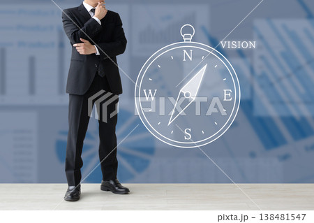 会社や企業のビジョンや経営の方向性を考えるビジネスマンと方位磁針 会社や企業のビジョンや経営の方向性を考えるビジネスマンと方位磁針 138481547