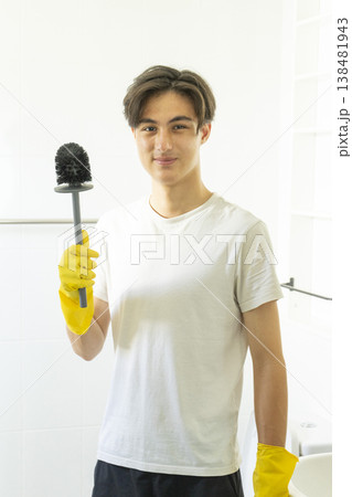 Young teen boy cleaning bathroom at home. Young teen boy cleaning bathroom at home. 138481943