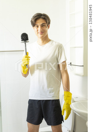 Young teen boy cleaning bathroom at home. Young teen boy cleaning bathroom at home. 138481945