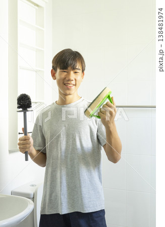 Asian young teen boy cleaning bathroom at home. 138481974